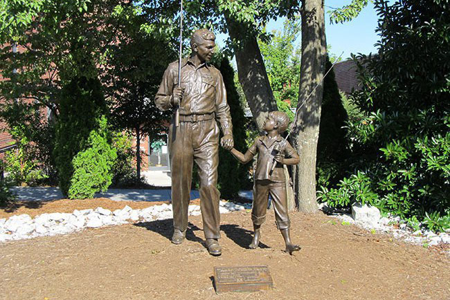 A bronze statue depicting widower Sheriff Andy Taylor (Andy Griffith) and his young son, Opie (Ron Howard). The statue depicts the scene where father and son are walking a dirt road with their fishing poles during the opening sequence and theme song of the show.